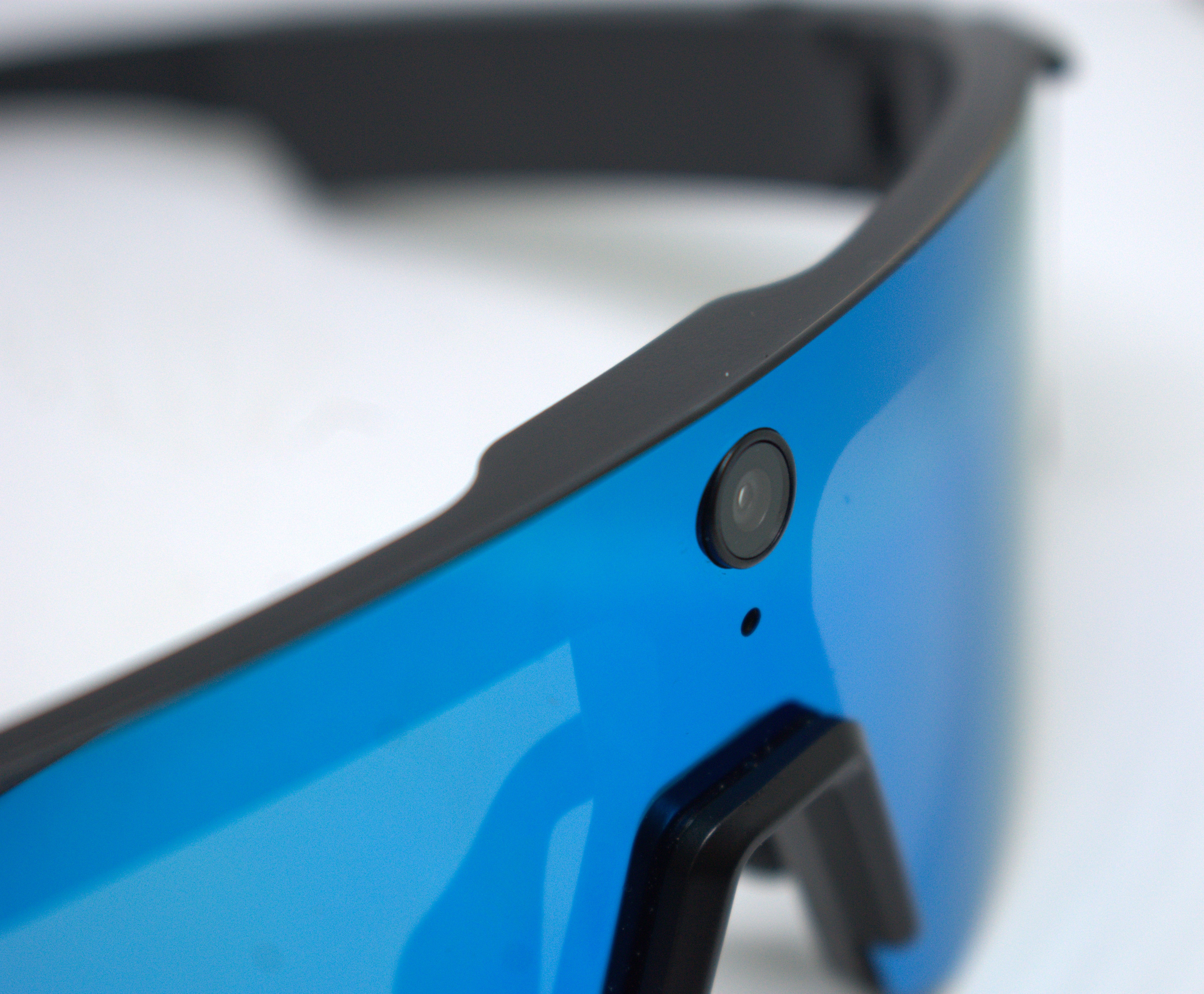 Close-up of the AYVYX IRIS camera lens, featuring a black exterior with a vibrant blue lens for high-quality imaging.